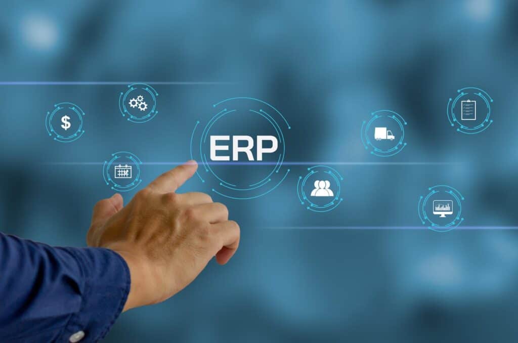Un hombre señala la palabra "erp" en una pantalla azul, destacando los beneficios de implementar un sistema.