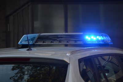 Un carro policial con luces azules en la parte superior que brinda seguridad y previene crímenes.