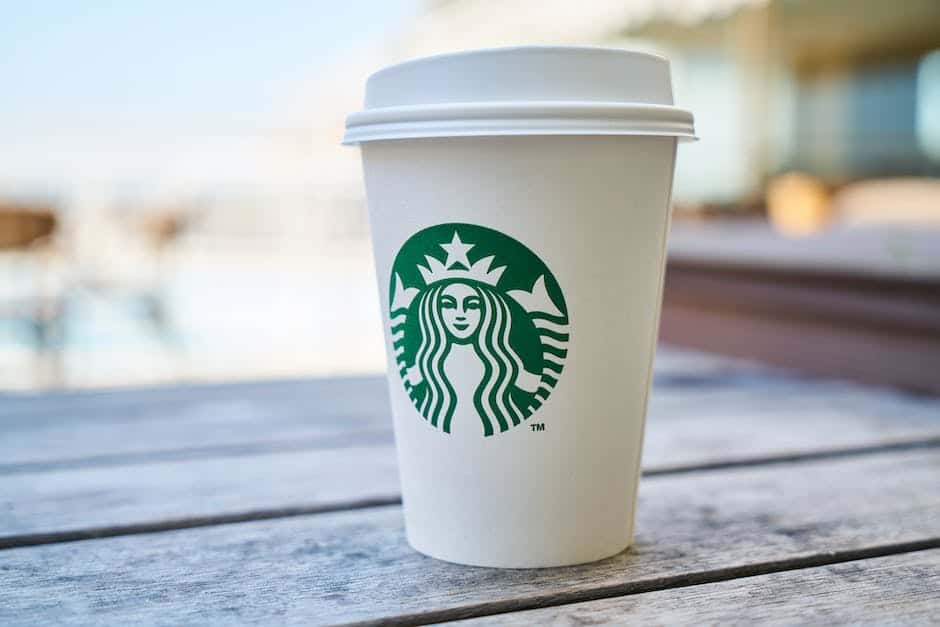 Una taza de café Starbucks se encuentra sobre una mesa de madera.