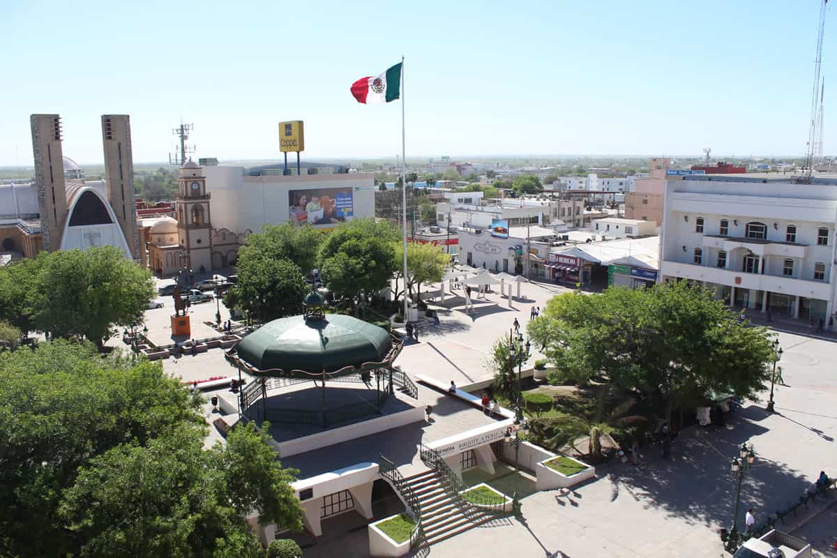 Una vista aérea de una plaza del pueblo con una bandera mexicana.