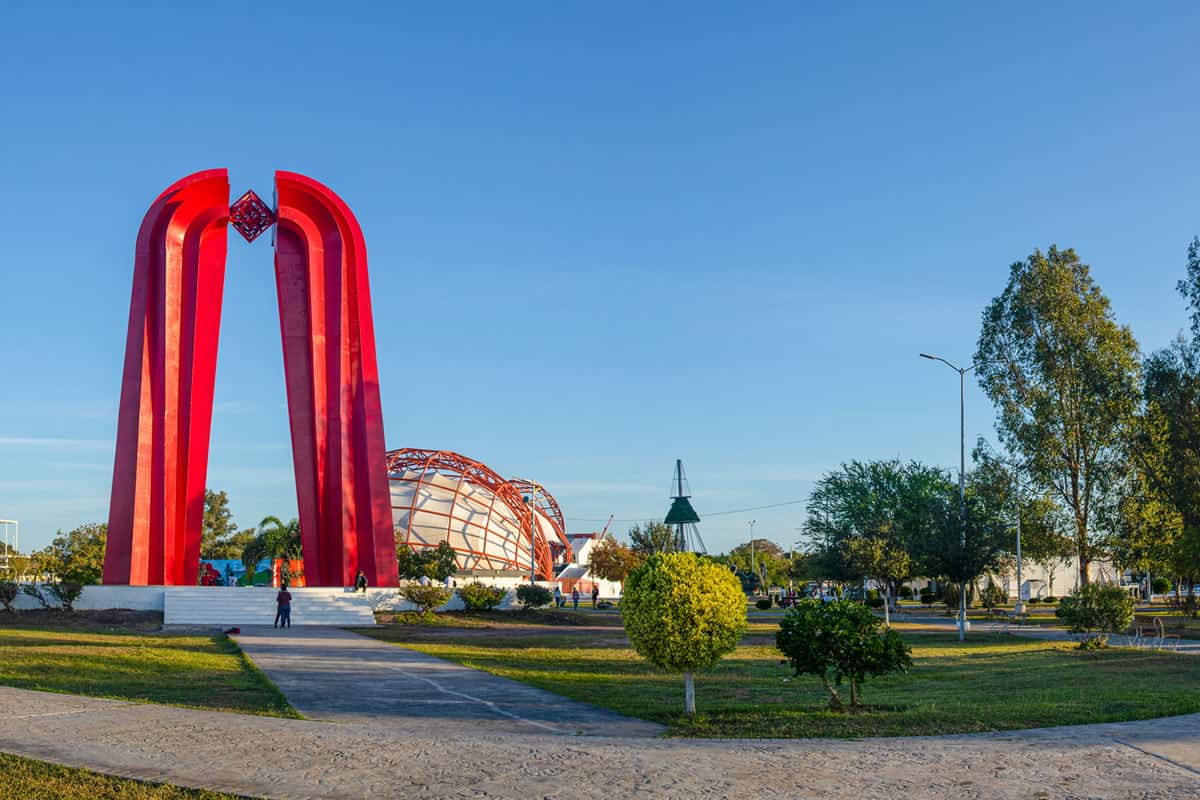 Una gran escultura roja en medio de un parque.