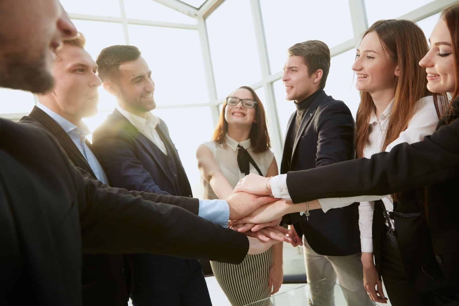 Un grupo de empresarios dándose la mano en una oficina.