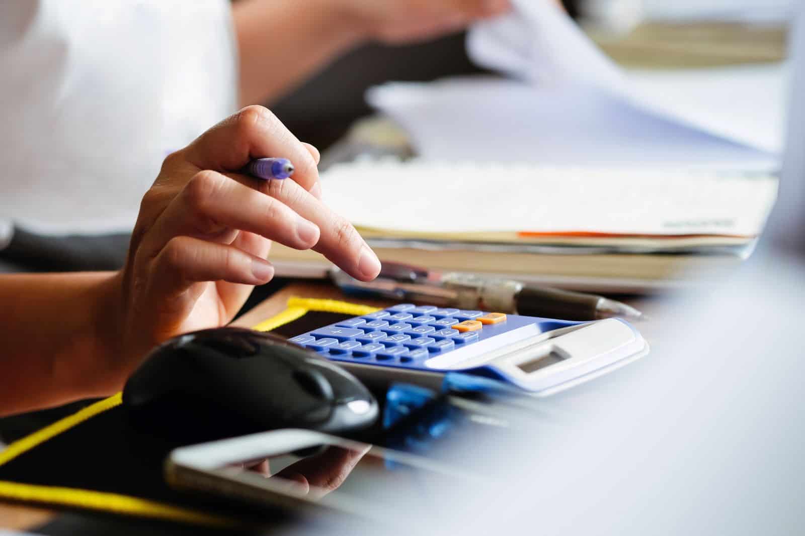 Una mujer usa una calculadora en su escritorio.