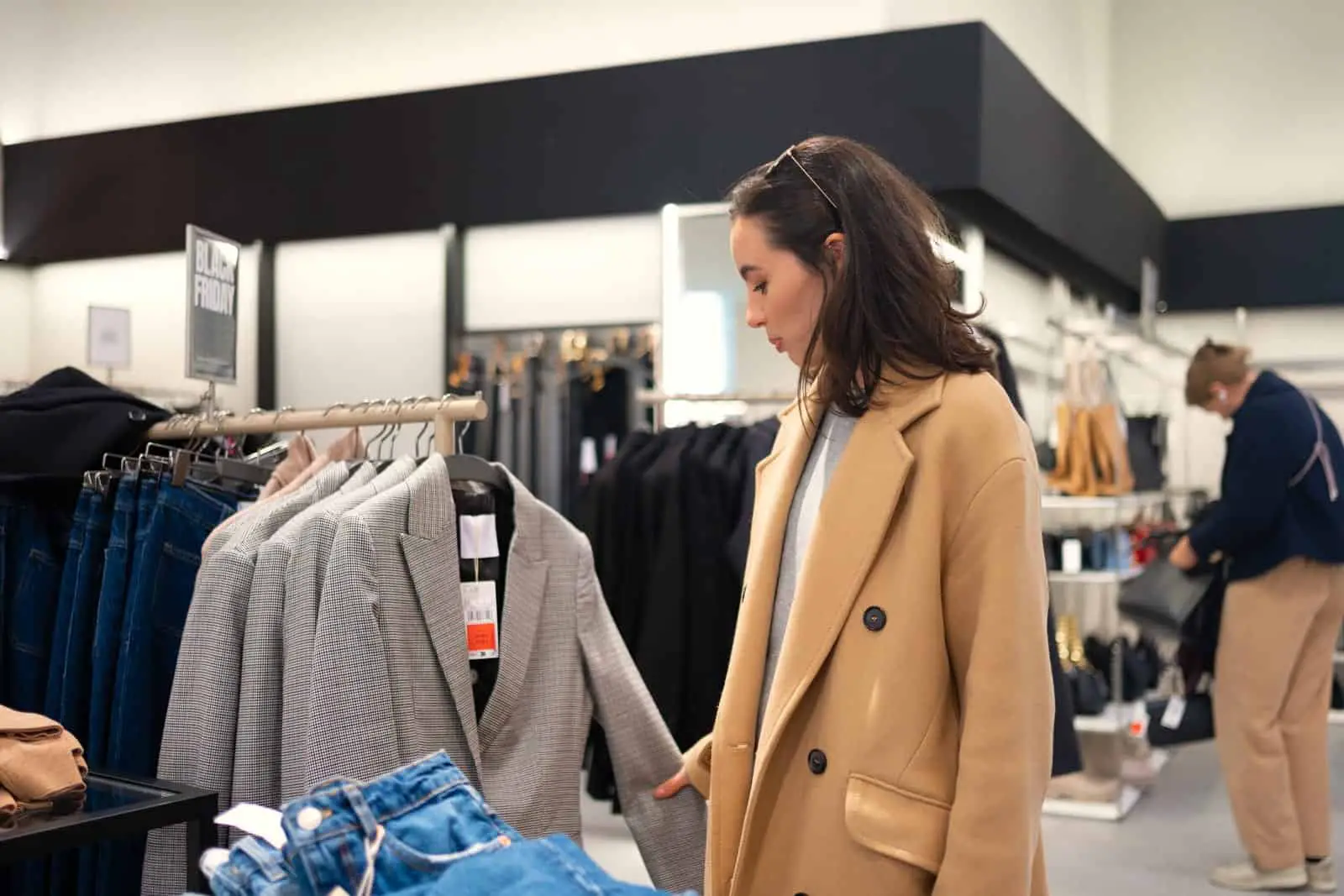 Una mujer mirando ropa en una tienda de ropa.